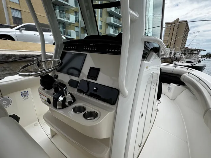  Yacht Photos Pics 2020 Boston Whaler 280 Outrage boat cockpit with steering wheel and control panel.