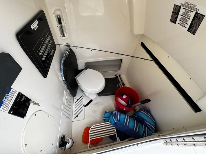  Yacht Photos Pics 2020 Boston Whaler 280 Outrage cabin interior with toilet, fishing gear, and storage.