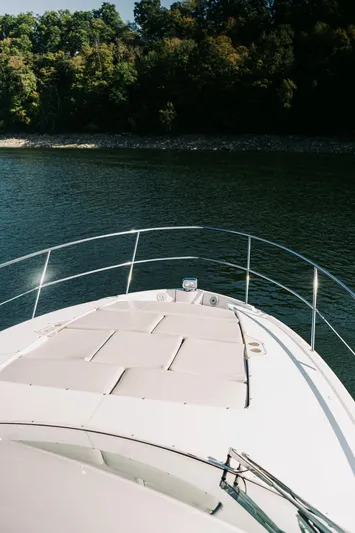  Yacht Photos Pics 2021 Regal 38 Grande Coupe yacht on serene water with lush forest backdrop.