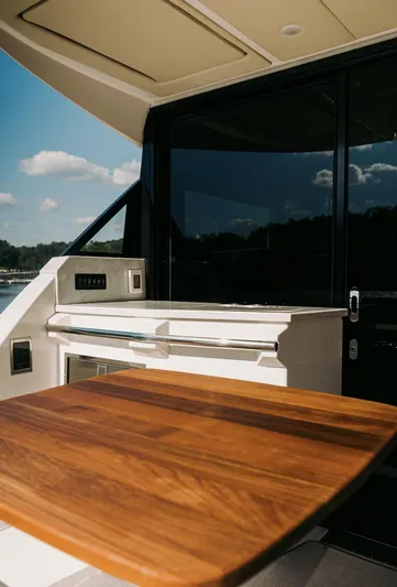  Yacht Photos Pics 2021 Regal 38 Grande Coupe yacht interior with wooden table and sleek design.