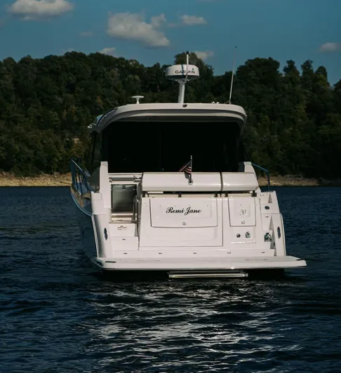  Yacht Photos Pics 2021 Regal 38 Grande Coupe yacht on a serene lake with forested background.