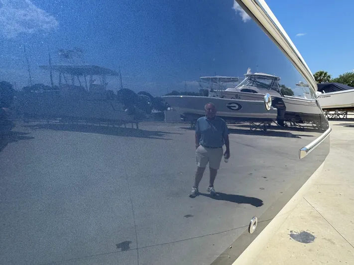  Yacht Photos Pics 2023 Chris-Craft Launch 28 GT boat with reflective hull in a sunny marina.