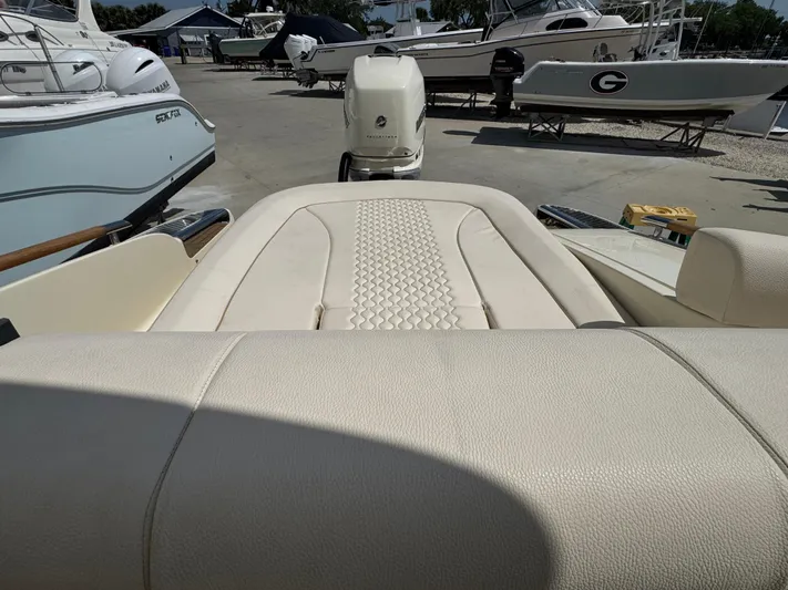  Yacht Photos Pics 2023 Chris-Craft Launch 28 GT boat interior with beige upholstery, docked among other boats.