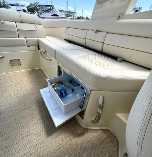  Yacht Photos Pics 2023 Chris-Craft Launch 28 GT interior with built-in cooler drawer and beige seating.