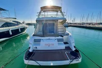 2007 Cruisers Yachts 447 Sport Sedan docked in a marina under clear blue skies.