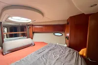 Luxurious cabin interior of 2007 Cruisers Yachts 447 Sport Sedan with cozy bedding.