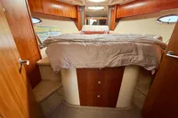 2007 Cruisers Yachts 447 Sport Sedan bedroom with wood accents and cozy bed.