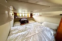 Interior cabin of 2007 Cruisers Yachts 447 Sport Sedan with cozy bed and porthole windows.