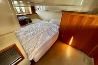 Interior cabin of 2007 Cruisers Yachts 447 Sport Sedan with cozy bed and wooden accents.