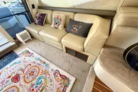 Interior of 2007 Cruisers Yachts 447 Sport Sedan with beige sofa and colorful rug.