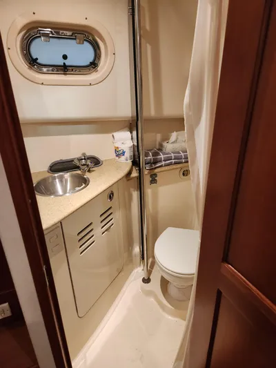  Yacht Photos Pics 2010 Mainship Pilot 31 boat bathroom with sink, toilet, and porthole window.