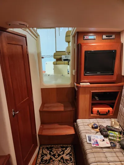  Yacht Photos Pics Interior of 2010 Mainship Pilot 31 boat with wood finish, TV, and seating area.