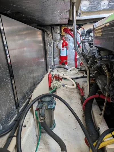 Yacht Photos Pics Engine room of a 2010 Mainship Pilot 31 boat, featuring mechanical components and fire extinguisher.