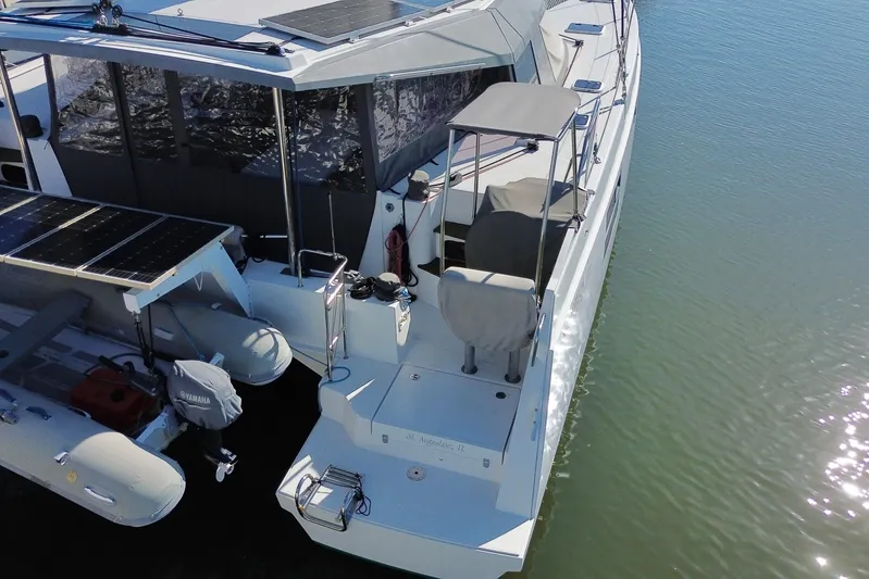 Muse Yacht Photos Pics 2019 Nautitech 40 Open catamaran with solar panels and dinghy, docked on calm water.