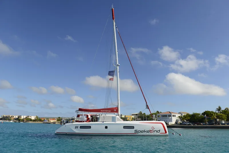 Spekeend Yacht Photos Pics 2021 Outremer 51 catamaran sailing in clear blue waters under a sunny sky.