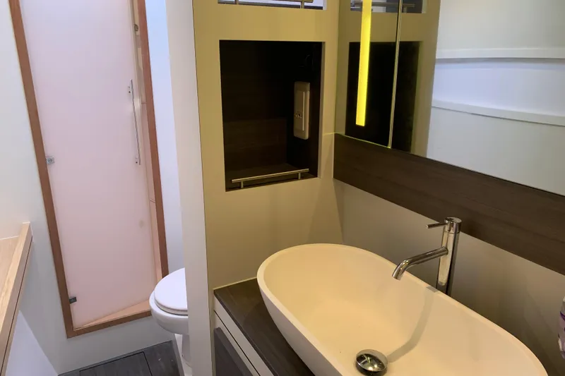 Spekeend Yacht Photos Pics Modern bathroom interior of 2021 Outremer 51 yacht with sleek sink and mirror.