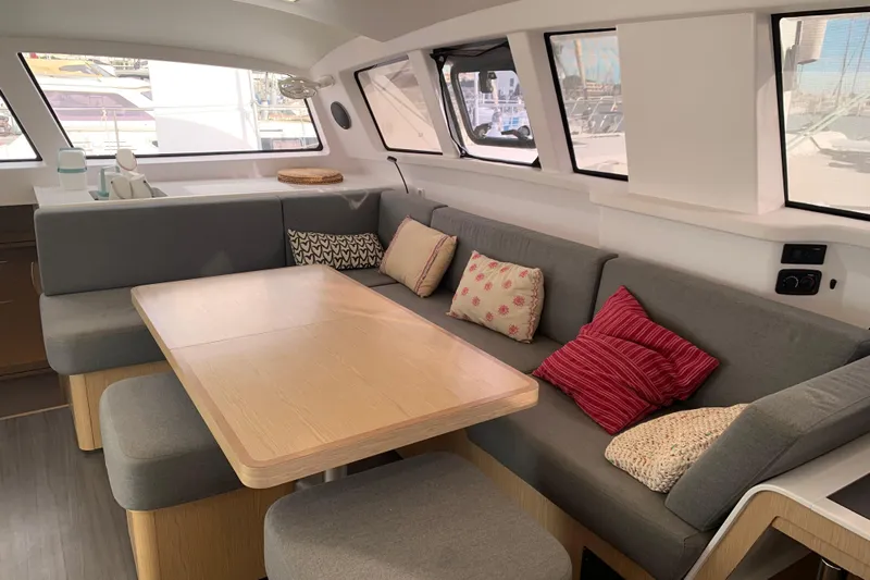 Spekeend Yacht Photos Pics Modern interior of 2021 Outremer 51 catamaran with cozy seating and dining area.