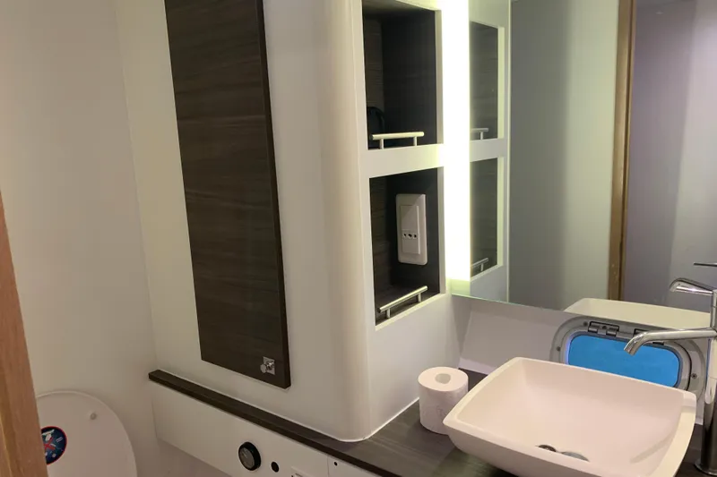 Spekeend Yacht Photos Pics Modern bathroom in 2021 Outremer 51 yacht with sink, mirror, and storage shelves.