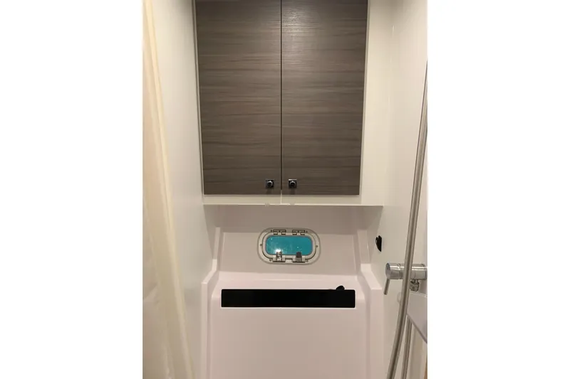 Spekeend Yacht Photos Pics Interior of 2021 Outremer 51 yacht, featuring sleek cabinetry and a small porthole window.