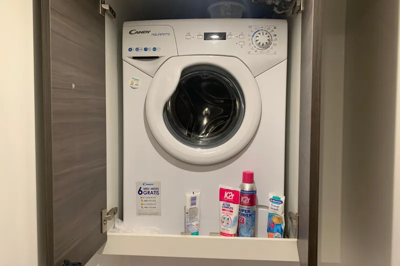 Spekeend Yacht Photos Pics Candy Aquamatic washing machine in cabinet with cleaning products, aboard 2021 Outremer 51.
