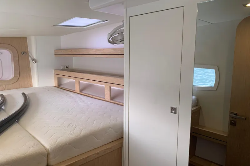 Spekeend Yacht Photos Pics Interior of 2021 Outremer 51 yacht cabin with bed, shelves, and window.