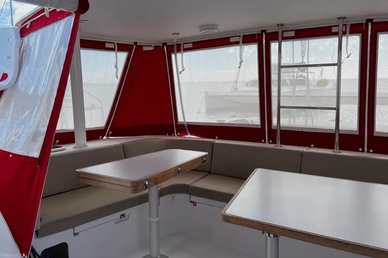 Spekeend Yacht Photos Pics Interior of 2021 Outremer 51 catamaran with red accents and seating area.
