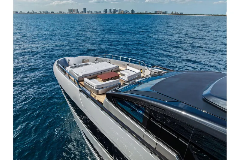 Euro Yacht Photos Pics Luxurious 2024 Riva 130' Bellissima yacht cruising on open sea with city skyline.