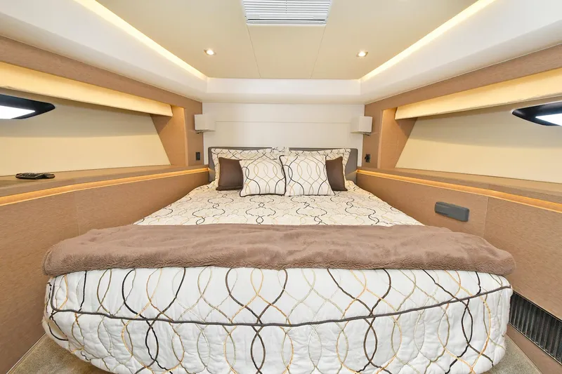  Yacht Photos Pics Luxurious bedroom interior of 2018 Prestige 560 Fly yacht with elegant bedding and ambient lighting.