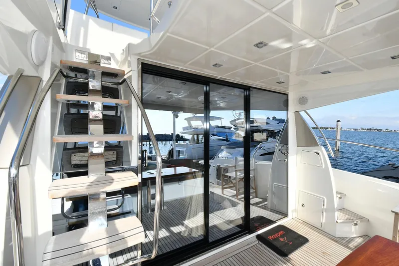  Yacht Photos Pics 2018 Prestige 560 Fly yacht interior with stairs, glass doors, and marina view.