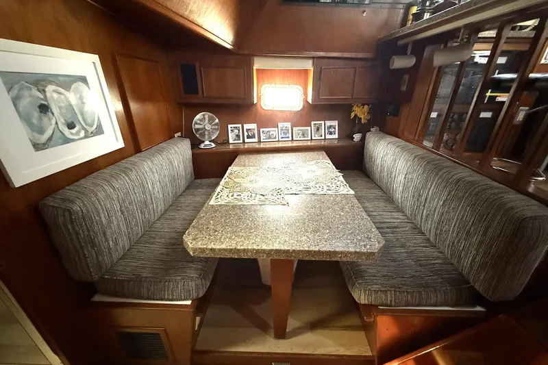 Luv'n Life Yacht Photos Pics Cozy dining area in 1989 Atlantic 47 Motor Yacht with cushioned seating and decorative table.