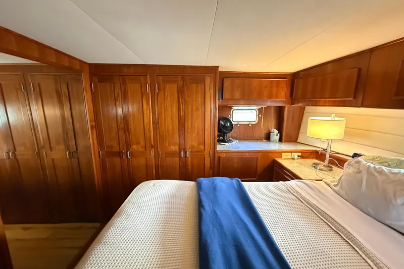 Luv'n Life Yacht Photos Pics Luxurious cabin interior of 1989 Atlantic 47 Motor Yacht with wooden finishes and cozy bedding.