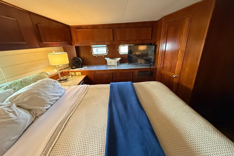 Luv'n Life Yacht Photos Pics Cozy bedroom in 1989 Atlantic 47 Motor Yacht with wood paneling and modern amenities.