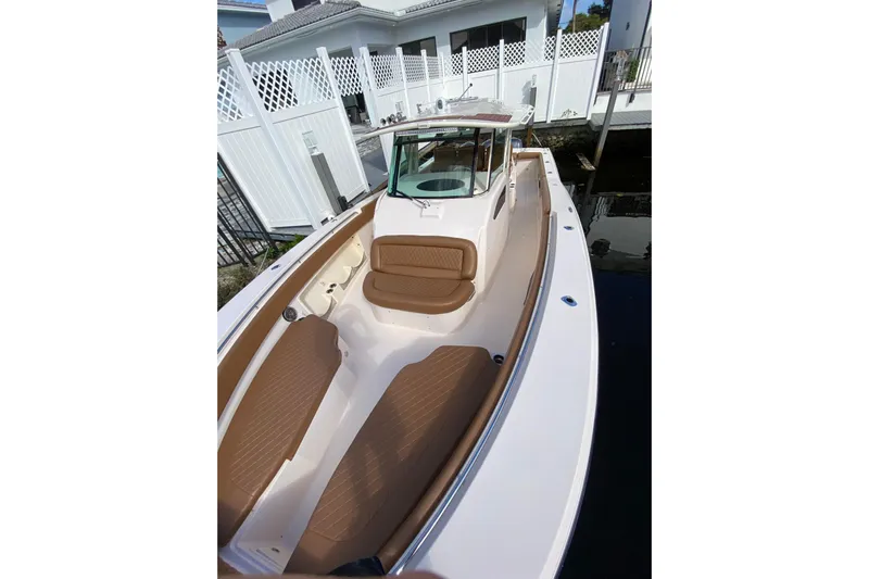  Yacht Photos Pics 2013 Grady-White Canyon 366 boat with tan seating, docked near a white fence.