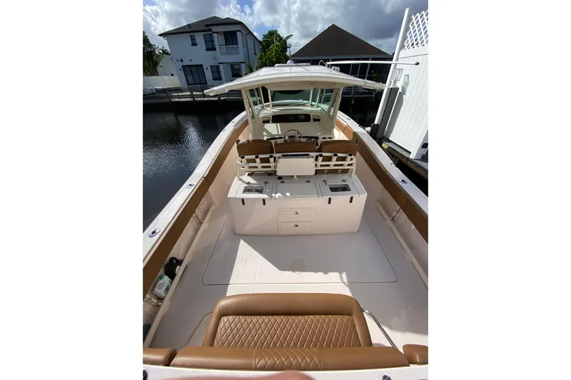  Yacht Photos Pics 2013 Grady-White Canyon 366 boat interior with seating and helm, docked by waterfront homes.