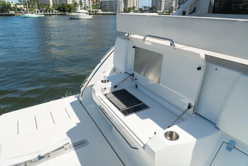Duke Yacht Photos Pics Outdoor grill on 2018 Cruisers Yachts 50 Cantius, docked by waterfront buildings.