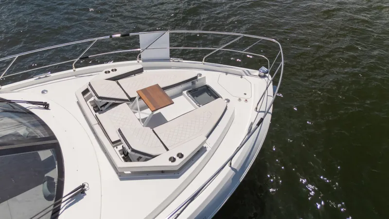 Duke Yacht Photos Pics 2018 Cruisers Yachts 50 Cantius bow with sunbathing area and table on water.