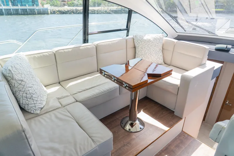 Duke Yacht Photos Pics Luxurious seating area on 2018 Cruisers Yachts 50 Cantius with elegant table and cushions.