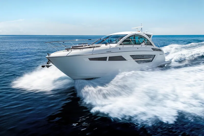 Duke Yacht Photos Pics 2018 Cruisers Yachts 50 Cantius speeding on open water, showcasing sleek design.