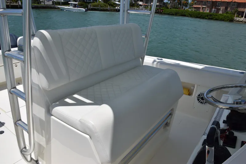  Yacht Photos Pics 2015 SeaVee 370z boat with white cushioned seating and steering wheel, docked near waterfront homes.