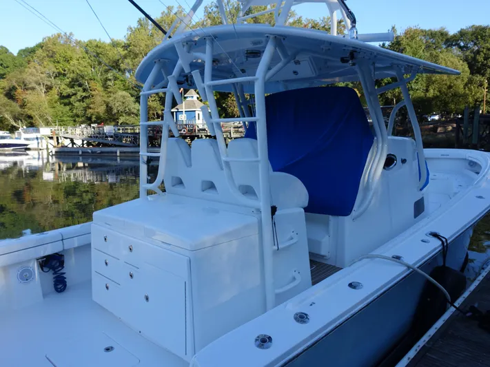 Yacht Photos Pics 2016 Regulator 41 boat with white deck and blue seating, docked by a scenic waterfront.