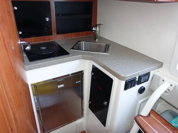  Yacht Photos Pics 2016 Regulator 41 boat kitchenette with sink, stove, and storage cabinets.
