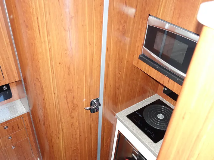  Yacht Photos Pics 2016 Regulator 41 interior with wood paneling, microwave, and induction cooktop.