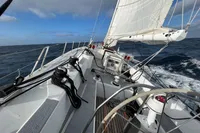 Sailing on a 1992 Devonport Challenge 67 yacht in open sea, clear skies above.