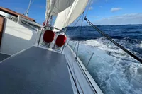 Sailing on Devonport Challenge 67 yacht, 1992 model, cutting through ocean waves under clear blue sky.