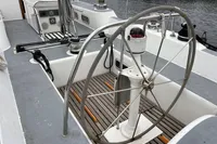 Steering wheel of a 1992 Devonport Challenge 67 yacht, docked at a marina.