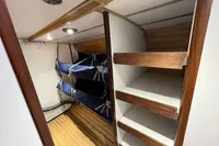 Interior of 1992 Devonport Challenge 67 yacht with bunk beds and wooden shelving.