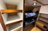 Interior of 1992 Devonport Challenge 67 yacht with bunk beds and wooden shelving.