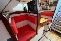 Red seating area in 1992 Devonport Challenge 67 yacht with navigation equipment.