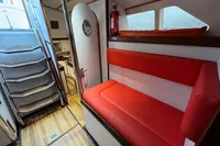 Interior of 1992 Devonport Challenge 67 yacht with red seating and wooden flooring.