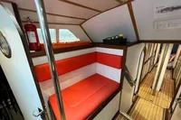 Interior of 1992 Devonport Challenge 67 yacht with red seating and wooden flooring.